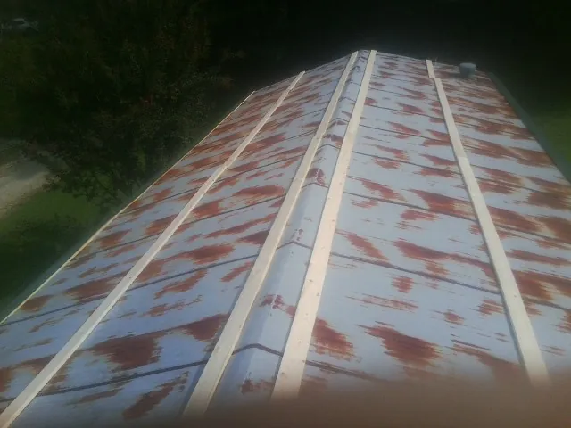 Rusted metal roof panels with new wood purlins before replacement — Storm Damage Roof Repair in Litchville by Roofing Brothers